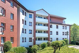 Ein Mehrfamilienhaus in der Friedrich-List-Straße 18: die Fassade hat weiße Elemente und Mauern aus rotem Backstein und breite Balkone