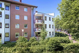 Das Mehrfamilienhaus in der Friedrich-List-Straße 22: Rückansicht des Hauses mit viel grüner Umgebung, Blick auf die Eckbalkone