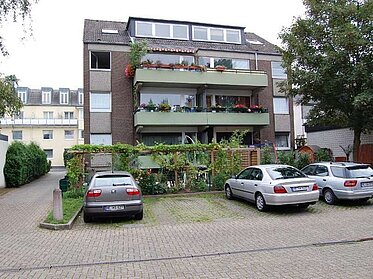 Parkplatz und Hecke vor der Balkonfassade eines unserer Mietobjekte in Langenfeld