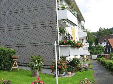 Zierpflanzen neben der Schiefer-Fassade eines unserer Mietobjekte in Siegen